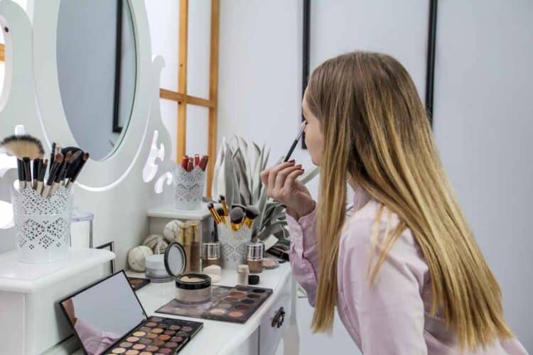 Looking herself into the mirror and doing her make-up